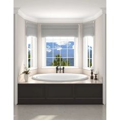 a large white bath tub sitting next to two windows