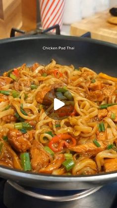 chicken pad thai in a wok on the stove