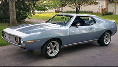 a blue muscle car parked on the street