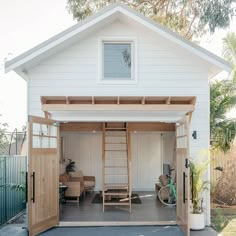 a white garage with a ladder to the roof