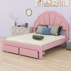 a pink bed sitting in a bedroom next to a white dresser and clock on the wall