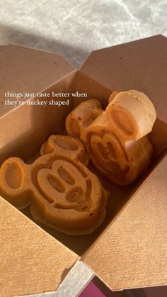 an open box with some cookies in it and a quote on the inside that says, things just taste better when they're mickey shaped