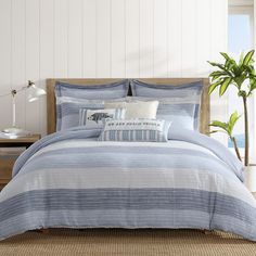 a bed with blue and white striped comforters