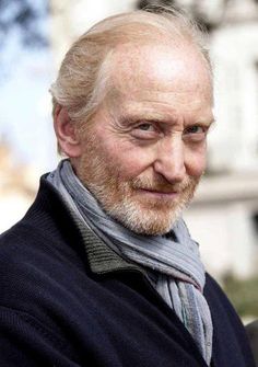 an older man with a beard and wearing a scarf