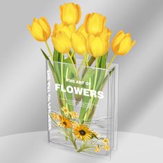 yellow flowers in a clear vase with the words art of flowers