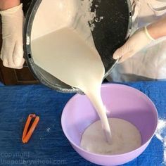 a person pouring batter into a purple bowl