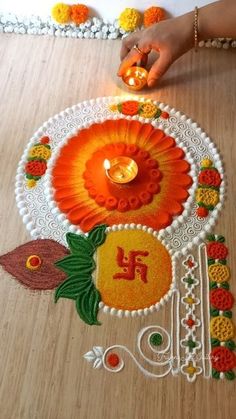 a woman is decorating the floor with flowers and candles for diwaling on it