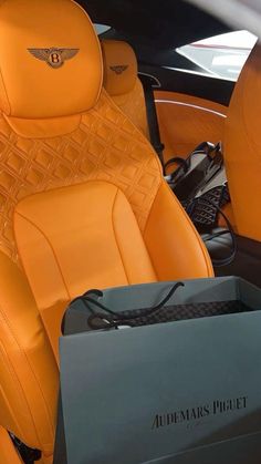 the interior of a luxury car with an orange leather seat cover and matching black trim