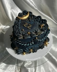 a black cake with gold stars and moon decorations