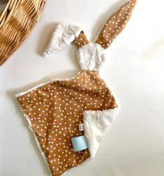 a brown and white polka dot bunny blanket next to a wicker basket