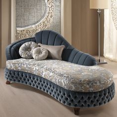 a blue couch with pillows on it in front of a large mirror and floor lamp