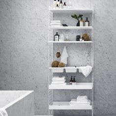 a bathroom with white marble walls and shelving