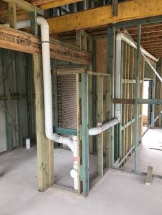 an unfinished room with exposed pipes and wood framing on the walls, along with other construction materials