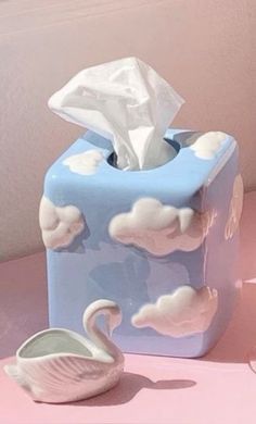 a tissue dispenser sitting on top of a pink table