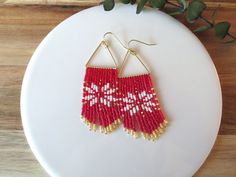 Inspired by the popular fair isle pattern that you see on winter sweaters, these earrings are just right for all of your holiday parties and events. Approx. size: 3 in. long by 1 in. wide. Handmade with love <3 Ear wires are 14K gold plated hypoallergenic. Design credit: Etsy shop HandMadeInUA **Each of my earrings are delicately handwoven bead by bead. I absolutely love making these and want you to know that each piece is made with patience, love, and care from start to finish! These earrings are made with size 11/0 Delica Japanese Miyuki glass seed beads. I use strong nylon thread to ensure the integrity of each earring.** Red And White Seed Bead Earrings, Christmas Seed Bead Earrings Patterns, Beaded Earrings Christmas, Winter Beaded Earrings, Seed Bead Christmas Earrings, Christmas Bead Earrings, Beaded Christmas Earrings, Christmas Beaded Earrings, Earrings 2024