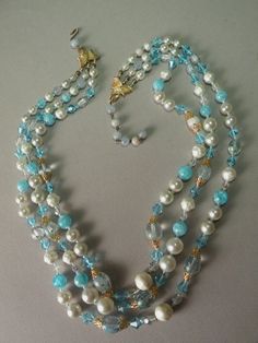 24 inch shortest strand with 3 inch adjustable bead chain vintage necklace features 3 strands of white & aqua colored lucite beads, glass bicone shaped aqua beads, with goldtone accents on a hook clasp. Clear Necklace, Three Strand Necklace, Aqua Beads, Bead Chain, Pearl Set, Hook Clasp, Gold Sparkle, Vintage Pearls, Multi Strand Necklace