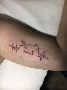 a person with a tattoo on their arm that has heartbeats in the shape of a dog