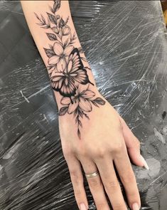 a woman's hand with a flower tattoo on it