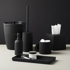 black bathroom accessories including soap dispenser, toothbrush holder and toiletries