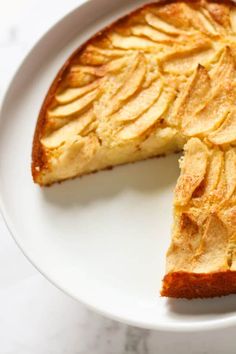 a white plate topped with a piece of cake next to a slice of apple pie