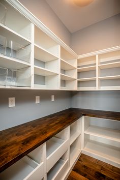 an empty room with white shelving and wood flooring