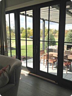 a living room with sliding glass doors leading to a patio and picnic table in the background