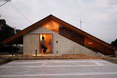 a person standing in the doorway of a building with an open roof and two windows