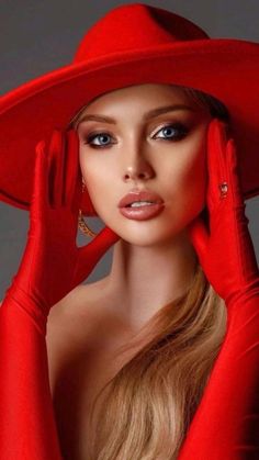 a woman with long blonde hair wearing a red hat and gloves, posing for the camera