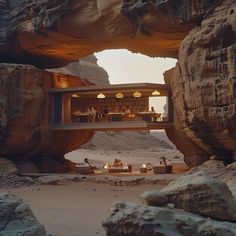 a desert setting with people sitting at tables under an arch