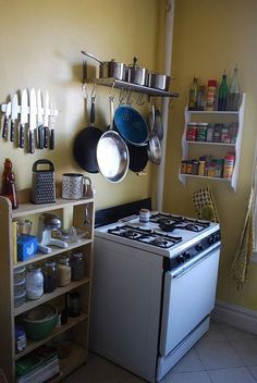 a kitchen with pots and pans hanging on the wall next to an electric stove