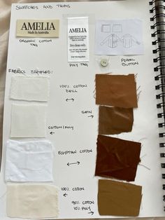 an open notebook with some brown and white papers on it, including different colored swatches