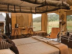 the inside of a tent with a bed, desks and other items in it