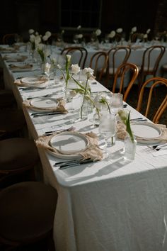 the table is set with plates and place settings