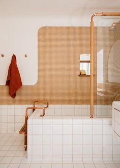 a bath room with a sink and a bath tub next to a shower head mounted on the wall