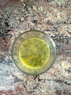 a glass bowl filled with green liquid on top of a granite counter