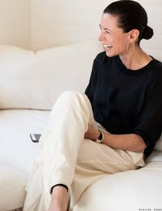 a woman sitting on a white couch smiling