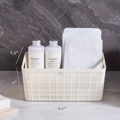 a white basket with three bottles and two pouches on the counter next to it