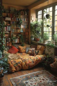 a living room filled with lots of plants and bookshelves next to a window