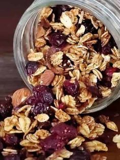 granola in a glass jar with dried cherries and almonds on the side