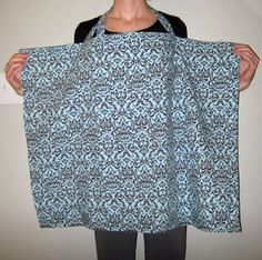 a woman holding up a blue and black patterned piece of cloth