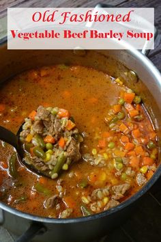 an old fashioned vegetable beef barley soup in a pot with a ladle scooping out