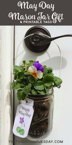 a mason jar filled with flowers hanging from the side of a white door and text that reads, may day mason jar giveaway & printable tags $ 6