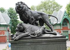 a statue of two lions on top of a lion laying down