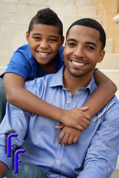 a man holding a little boy in his arms