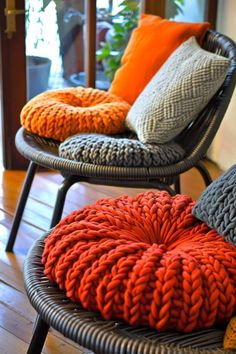 two wicker chairs with knitted cushions on them