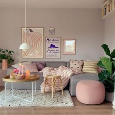 a living room filled with lots of furniture next to a wall covered in pictures and plants