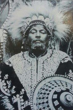 an old photo of a man with feathers on his head