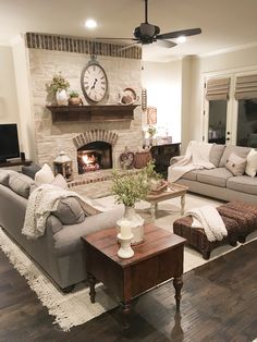 a living room filled with furniture and a fire place in the middle of the room