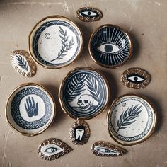 six decorative plates with hand and eye designs on them, all decorated in different styles