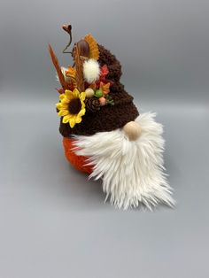 a gnome's hat with feathers and sunflowers on the top is shown